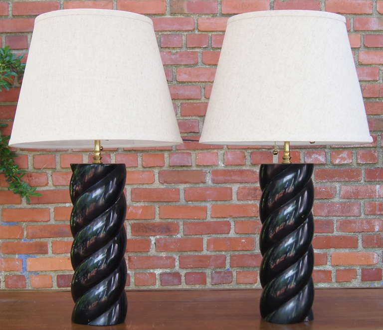 A pair of mid-20th century black lacquered mahogany barley twist table lamps with fine brass fittings.