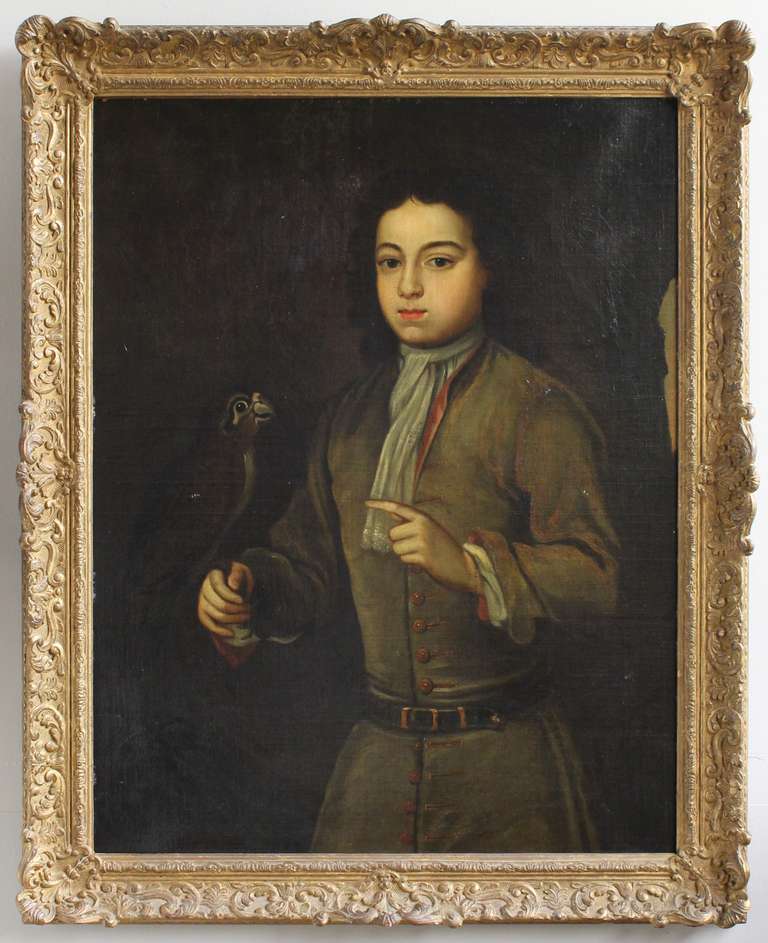 Huile sur toile anglaise du milieu du 18e siècle représentant un garçon tenant un oiseau:: soit un faucon de chasse:: soit un perroquet exotique de compagnie:: dans un beau cadre ancien:: peut-être d'origine.