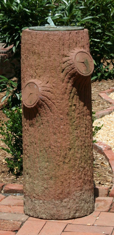 A massive sundial made from hand-carved brownstone simulating the shorn limbs of an old tree and topped with its original verdigris bronze dial plate.