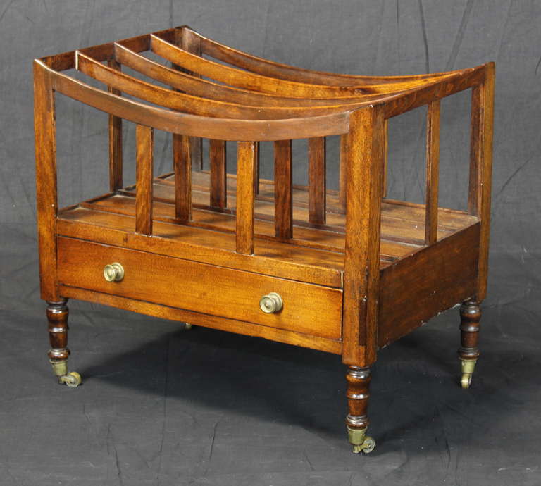 A fine and elegant George III mahogany boat shaped canterbury having one drawer raised on elegant turned legs with brass casters.
