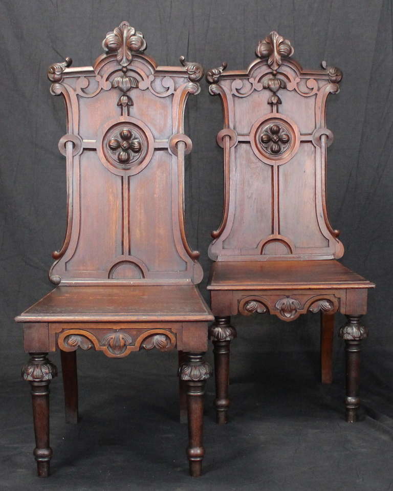 An unusually large pair of English carved mahogany Gothic Revival hall chairs dating from the 1840's.