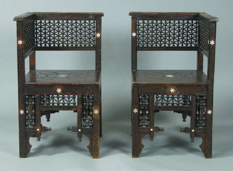 A charming pair of late 19th century Syrian corner chairs intricately carved and inlaid with mother of pearl