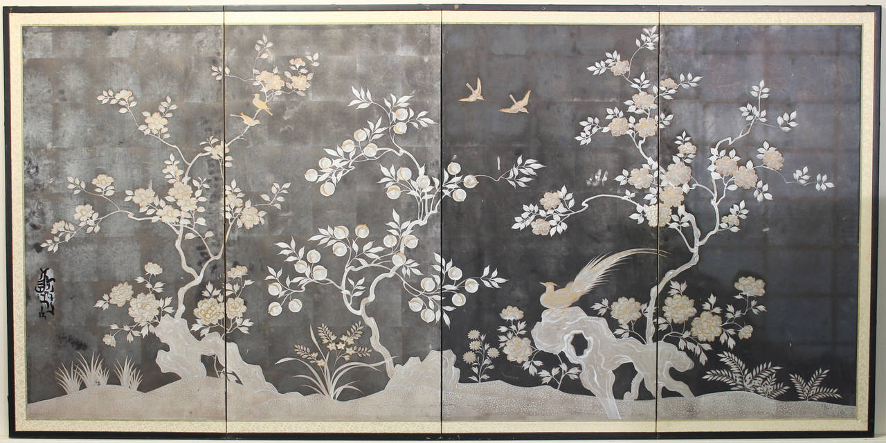 An elegant late 19th century to early 20th century Japanese painted folding screen depicting white and gold trees and birds against a silver-leaf sky background.