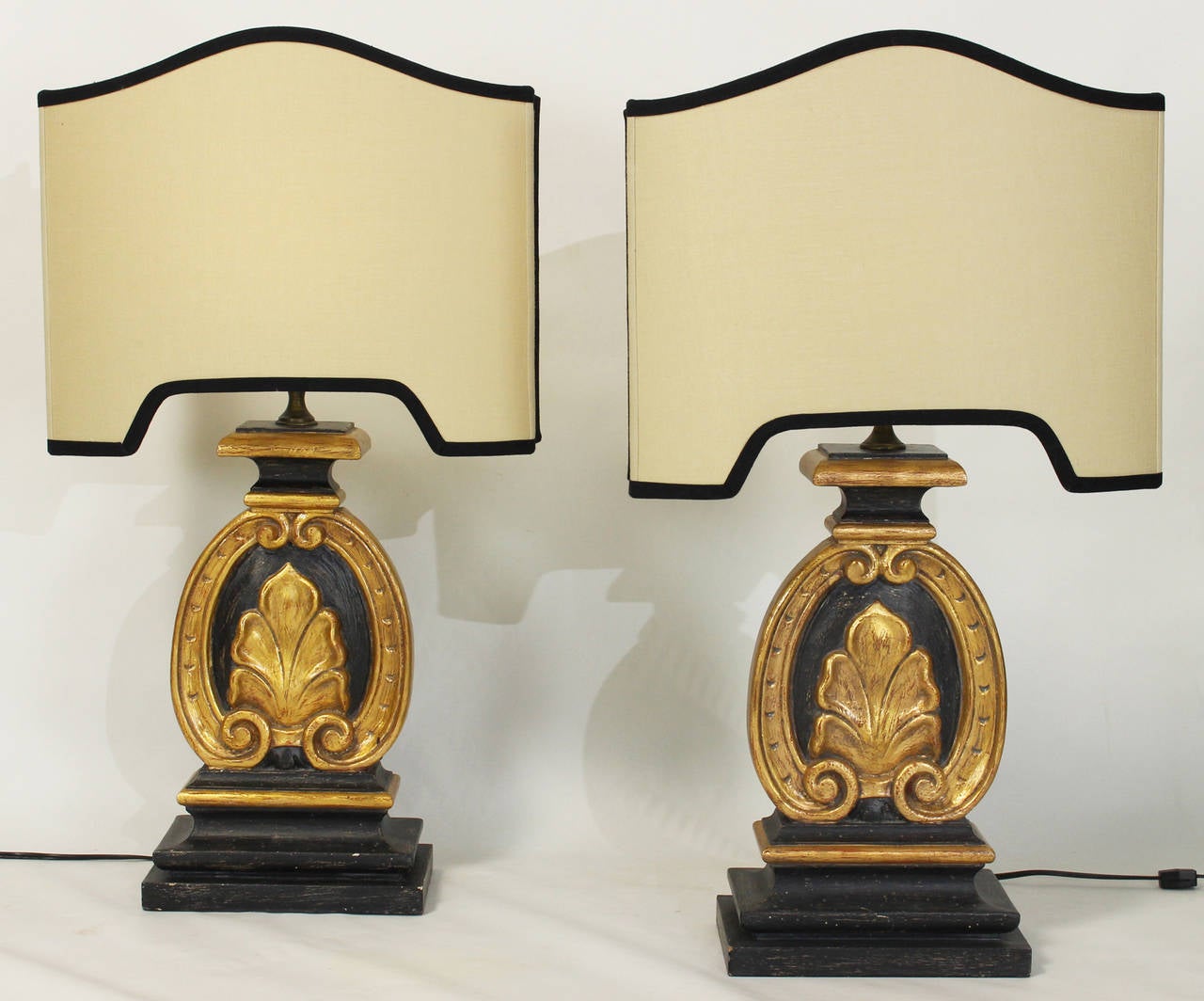 A pair of Italian carved wood and paint decorated table lamps with custom silk shades.