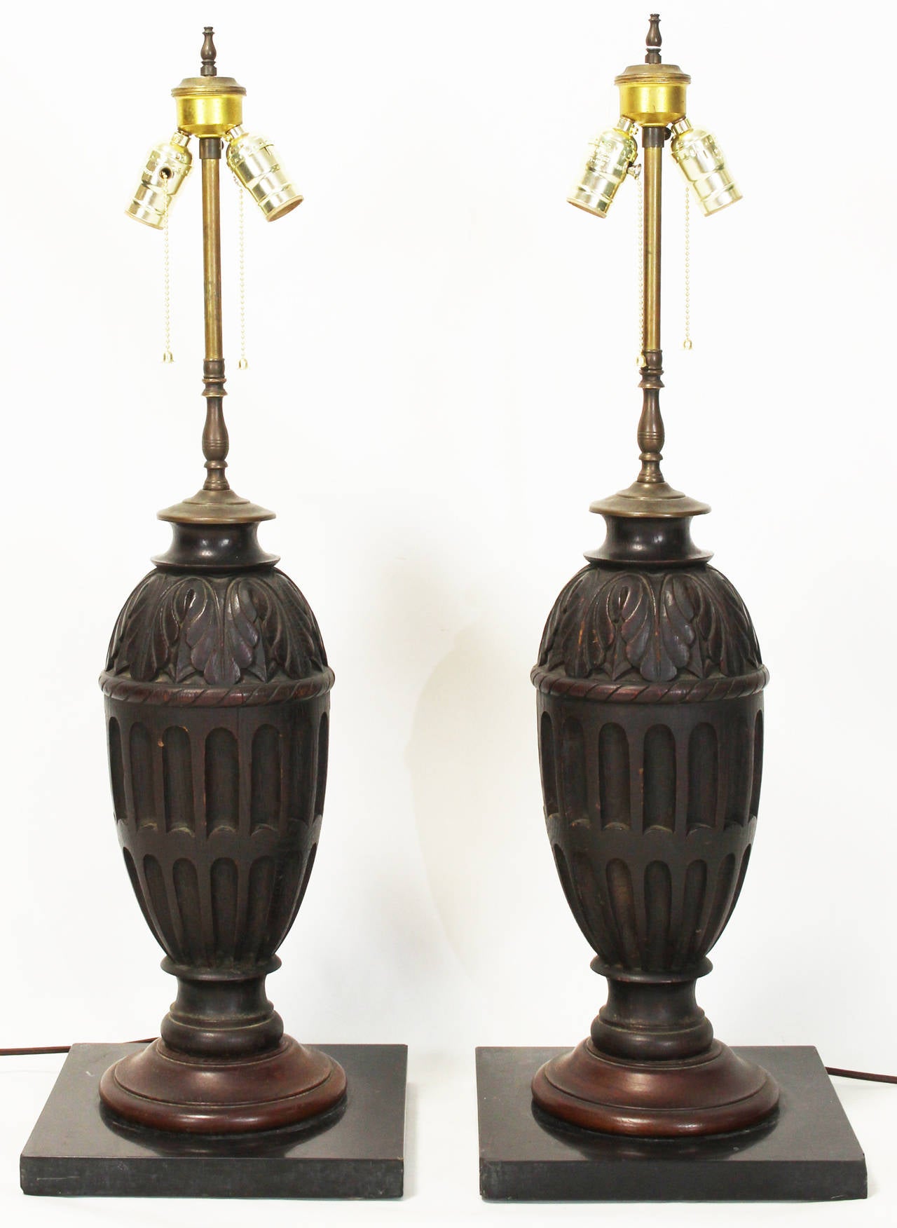 A pair of large carved wood table lamps on marble bases dating from the 1930s.