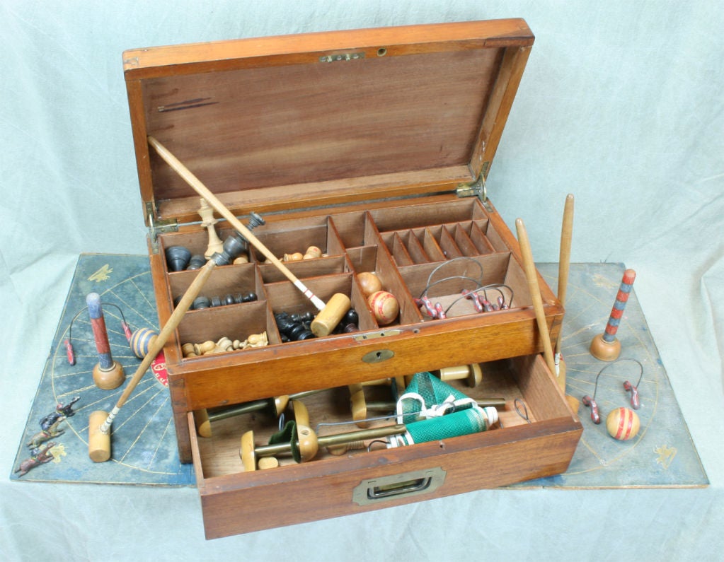 A wonderful Edwardian mahogany two compartment games box featuring a variety of indoor games: carpet croquet, draughts, chess, table tennis, backgammon, and others