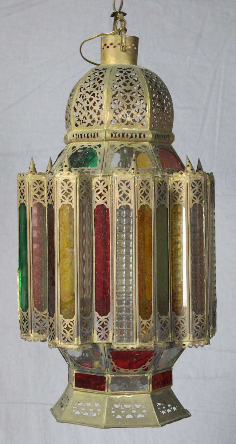A large and colorful Moroccan lantern featuring pierced brass set with jewel colored glass dating from the first half of the 20th century.