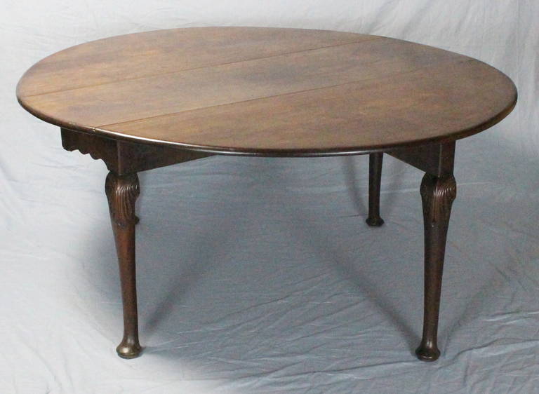 A large and impressive late 18th century English mahogany drop-leaf dining table, the moulded edge top, with hinged demilune leaves, carved knee ending in pad feet, lovely old finish with beautiful imperfections.