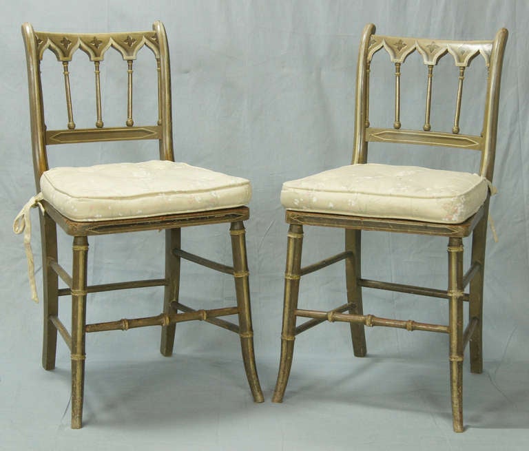 An exceptionally charming pair of English, paint decorated Gothic Revival side chairs dating from the 1880's.
