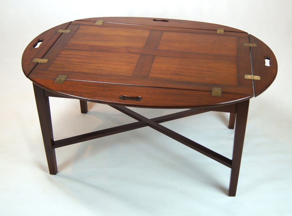 A very large, early 19th C. mahogany butler's tray of oval form with rectangular center and hinged leaves with shaped open handles, on custom made stand of a later date.