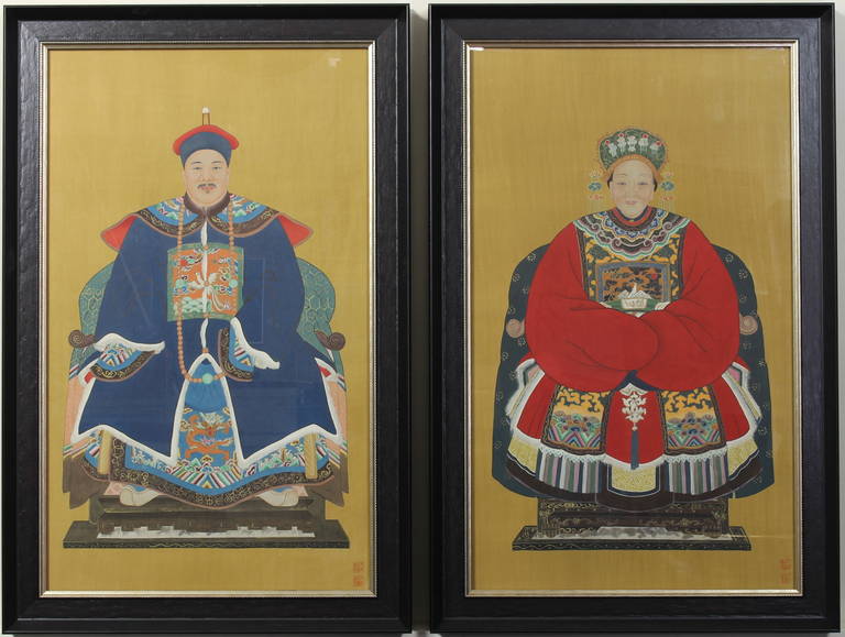 A pair of early 20th century Chinese ancestral paintings depicting a Mandarin and his wife in winter costume. Both are signed bottom right.