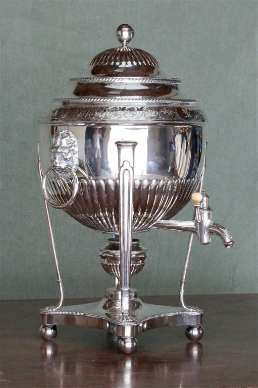 A large and elegant Sheffield tea urn, silver over copper, with original English oak traveling case.