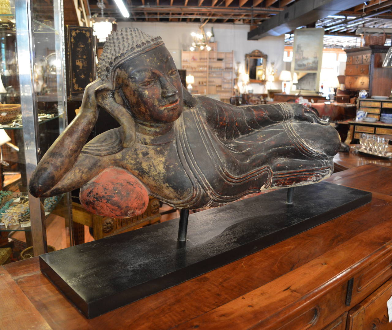 Antique, carved polychrome and gilt Buddha, reclining, mounted on later Stand, 19th century, possibly earlier.
