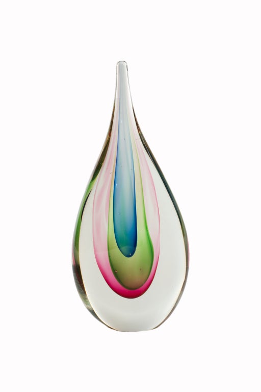 An Italian 1950s sculptural hand blown sculptural art glass vase by, Flavio Poli for Seguso in the shape of a stylized teardrop encased in clear glass with vibrant pink , green , blue fading to purple at the tip of the drop. The vase is unsigned.