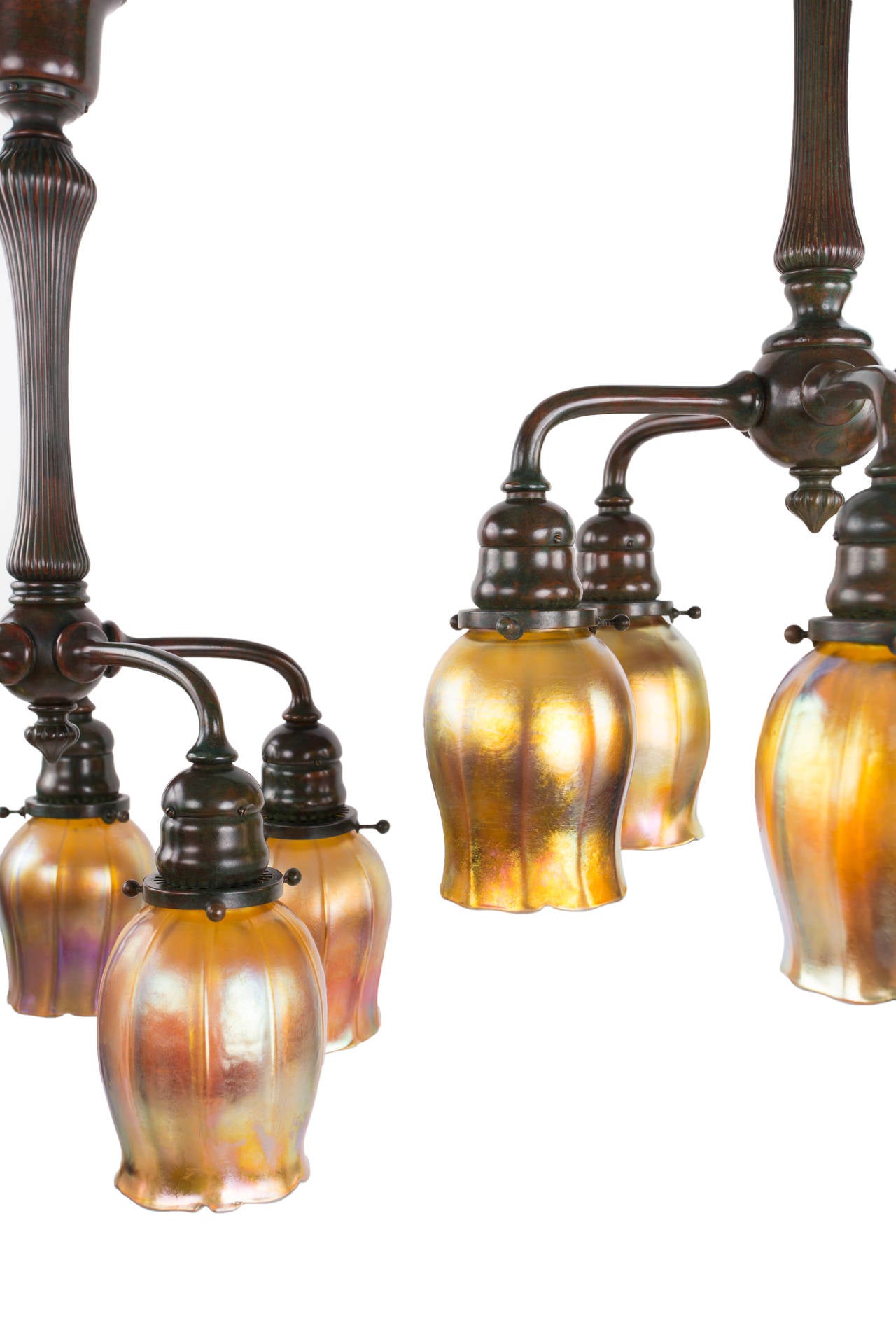 A fine and rare matching pair of patinated bronze and glass chandeliers by, Tiffany Studios each decorated five matching blown glass Tiffany Favrile 