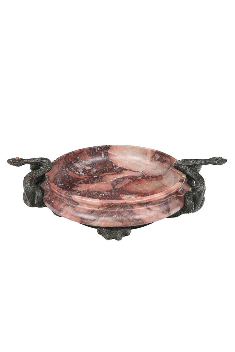 A 19th Century Continental bronze and marble centerpiece decorated with beautiful red-purple marble bowl further decorated with two intertwined bronze serpents each with an orange cabachon jewel a top their heads. The centerpiece is unsigned.