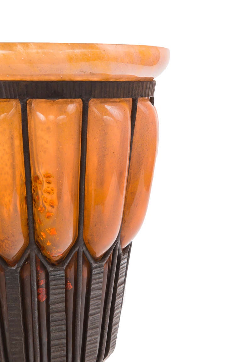 An impressive French Art Deco glass & wrought iron vase by, Louis Majorelle and Daum Nancy with orange-peach colored glass with gold flakes blown into a wrought iron base. The vase is signed, 