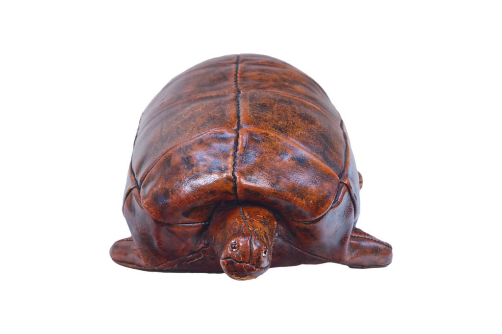 A leather turtle footstool with glass eyes manufactured by Omersa and Company, Lincolnshire, UK and retailed by Abercrombie & Fitch Company  from 1940s -1960s The turtle is branded on the ubderside 