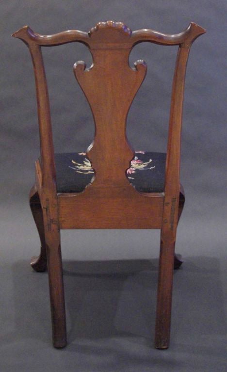 Shell carved serpentine crestrail above solid vasiform splat, slip seat with cabriole legs ending in stockinged trifid feet.