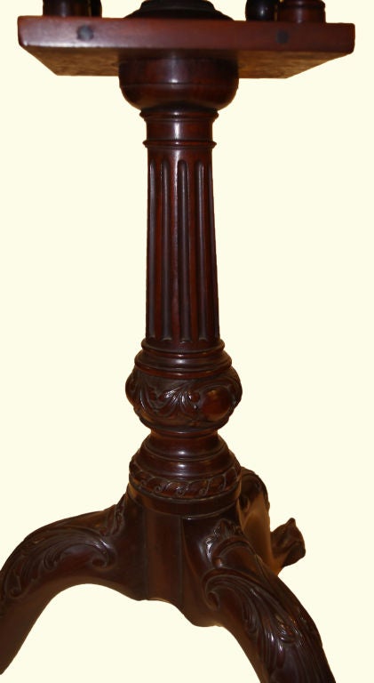 Circular pie crust top, tilts on a bird-cage support, slightly flaring fluted pedestal terminating in a leaf carved suppressed ball, tripod leaf carved cabriole legs on ball and claw feet.