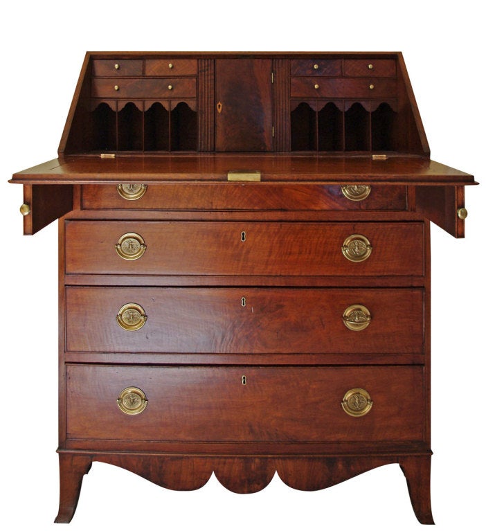 Containing fitted interior cubby holes centering an inlaid prospect door all above the four cock beaded long drawers with contemporary stamped American eagle brasses with bale handles, raised on a shaped skirt continuing to French bracket feet with