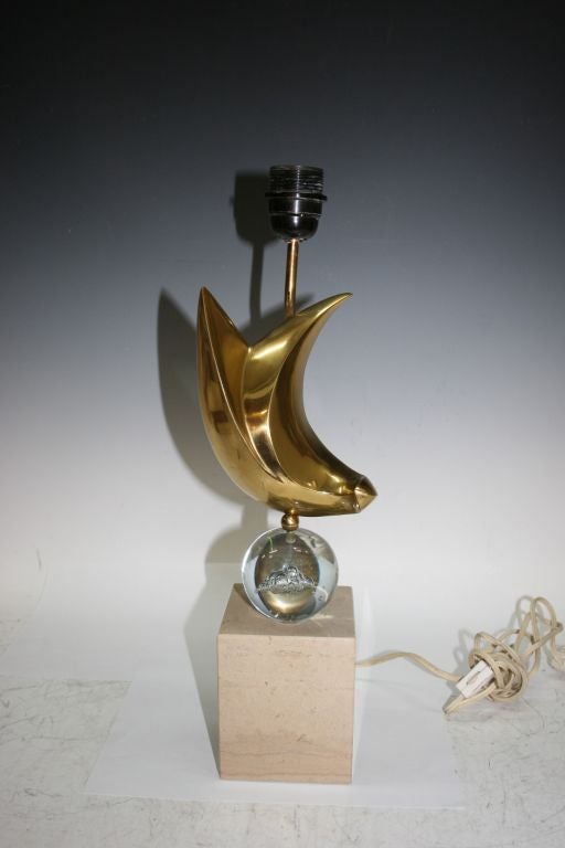 Rare sculptural table/desk lamp by French sculptor Philippe Jean. A rotating abstract brass bird sits atop a handblown glass sphere over a travertine marble square pedestal. Signed 