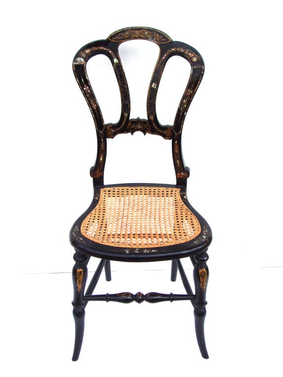 An antique ballroom chair with a scalloped back and caned seat. The papier mache frame has mother of pearl and gold painted detailing

Previously reduced from $650.00