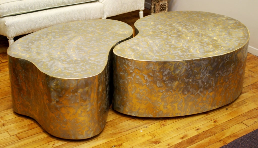 A pair of vintage free-form tables on casters that can be utilized together as a coffee or cocktail table, or split up as side tables. They are in a patinated, hammered brass/bronze finish and are signed by Silas Seandel on the edge. 

Dimensions
