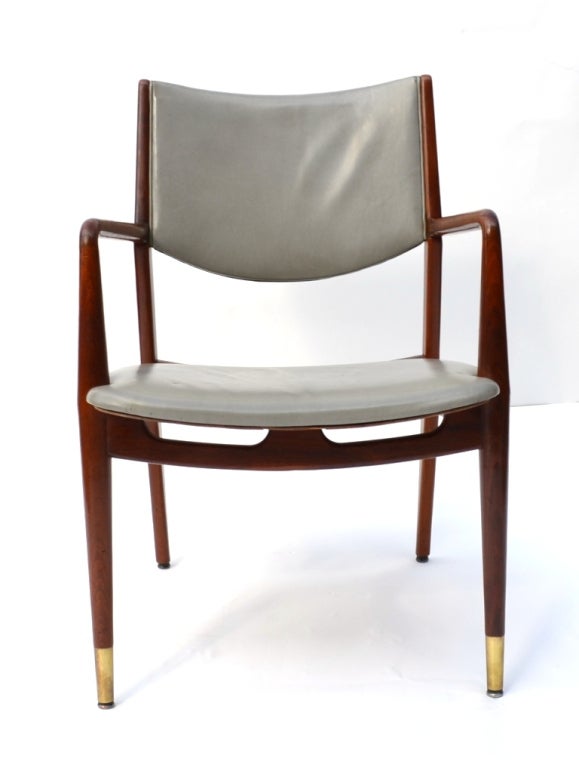 A single vintage chair in walnut with grey leather upholstery by Stow and Davis furniture company of Grand Rapids. The front legs have brass cap detailing.