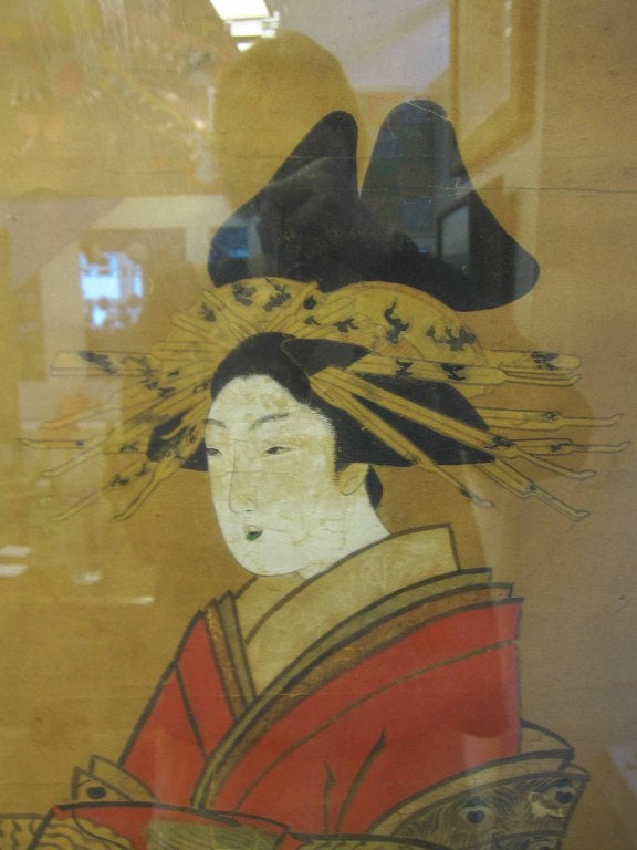 A vintage Japanese painting on paper of a geisha in a red robe with dragon and floral design. The piece is in a gold-tone wood frame.
