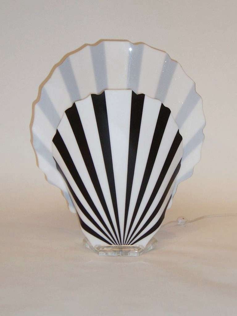 A vintage acrylic table lamp with black and white fan shaped front and back shades. It is by Luminaire