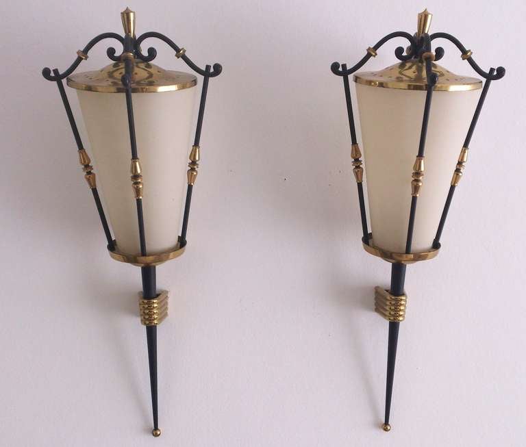 A pair of vintage lantern form sconces by Arlus with a brass and black enameled frame and opaque cloth-paper shade. They are in good vintage condition with age appropriate wear. Some scratches. European sockets and wiring