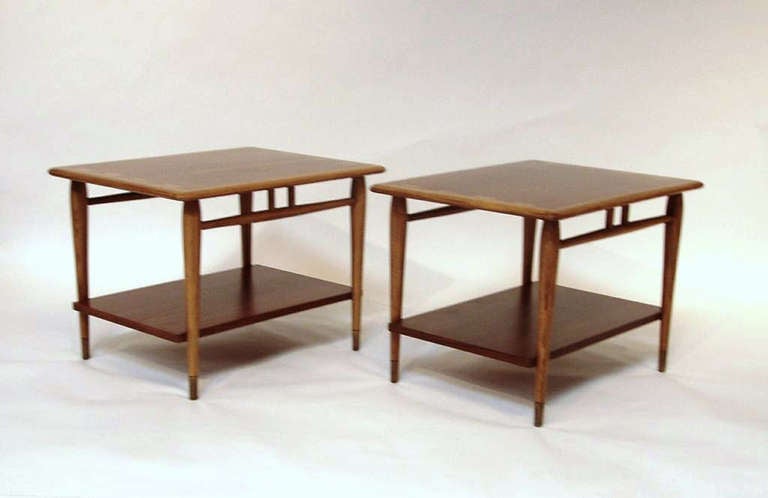 A pair of vintage end tables by lane with two tiers and a dovetailed border detail on the top surface of each table.