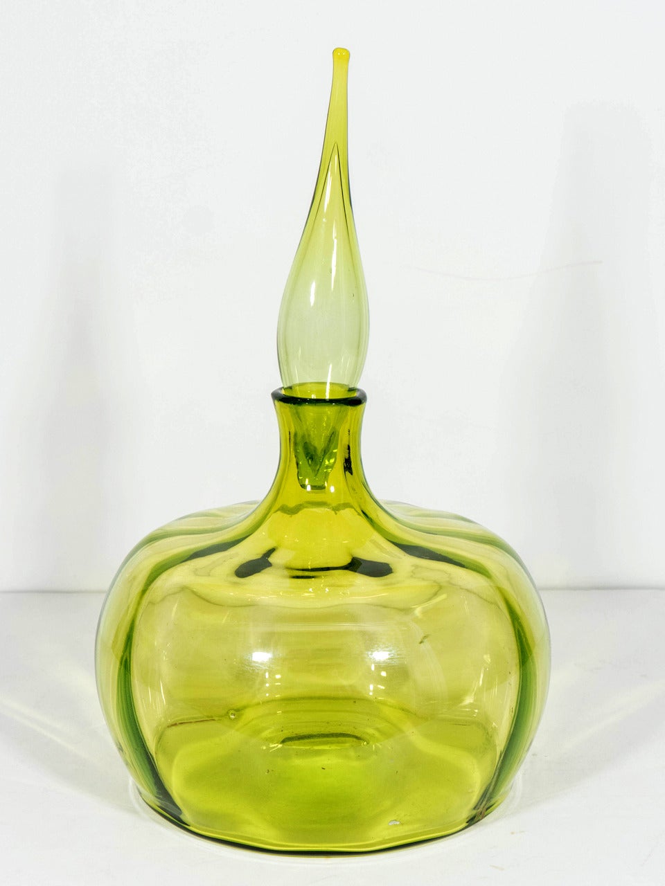 A vintage Blenko # 6417 blown glass pumpkin shaped decanter with tall flame stopper in olive. Designed in 1964 by Joel Myers for the Blenko Glass Co. of Milton, West Virginia. Excellent vintage condition.