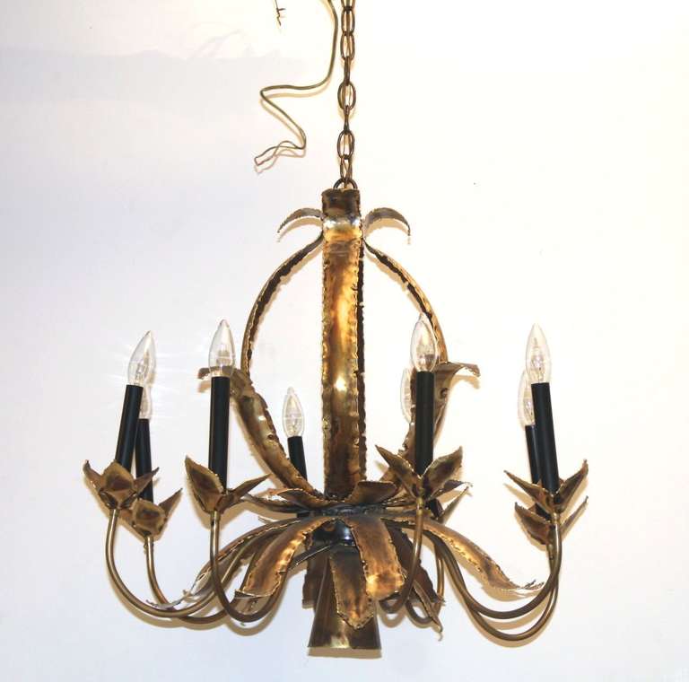 A vintage brass chandelier with a leaf and vine motif. The piece is by Tom Greene for Feldman.