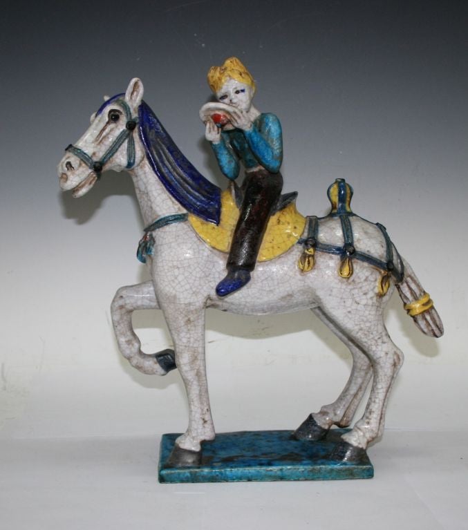Very rare ceramic figure by Fantoni, depicting a highly decorated jockey on a horse with tasseled saddle and bridle. Glazed in bright yellow, lapis blue, turquoise, black white with all-over craquelure effect. Marked 