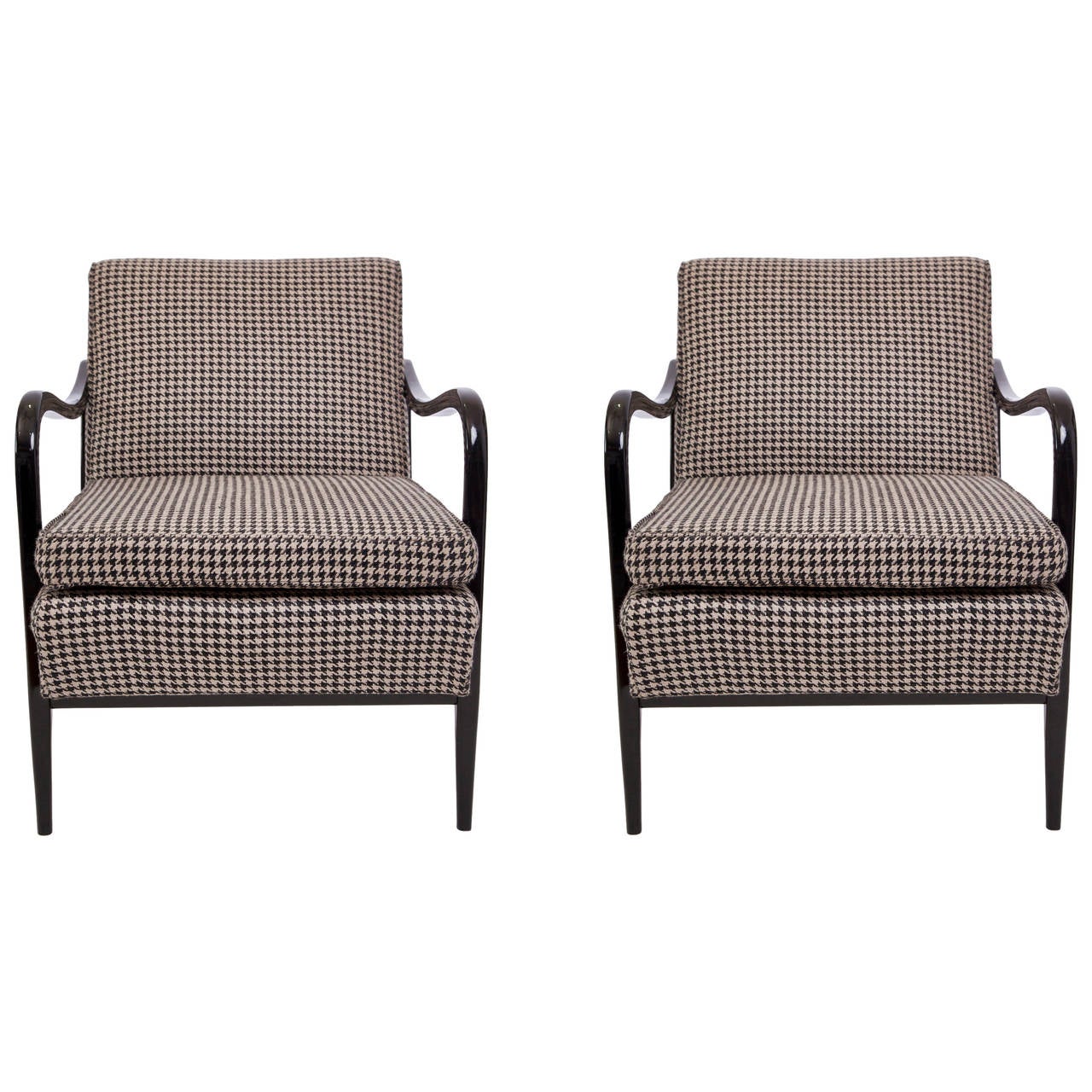 A vintage pair of modernistic armchairs, produced, circa 1950s, with rounded waterfall arms in ebonized wood on tapering legs, the cushioned back and seat upholstered in fabric with black and white hounds-tooth patterns. Good vintage condition, with