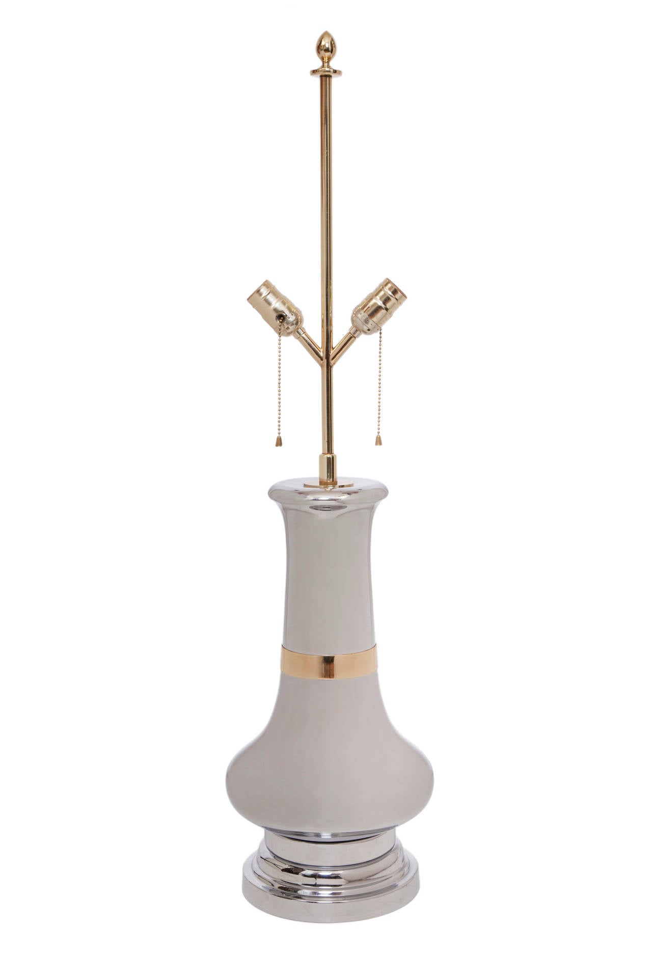 A pair of vintage table lamps, produced circa 1970s, with angled, double-cluster sockets, set mid-length against a brass stem, above a baluster body in plated chrome, with polished brass band, above a stepped circular foot. Wiring and sockets to US