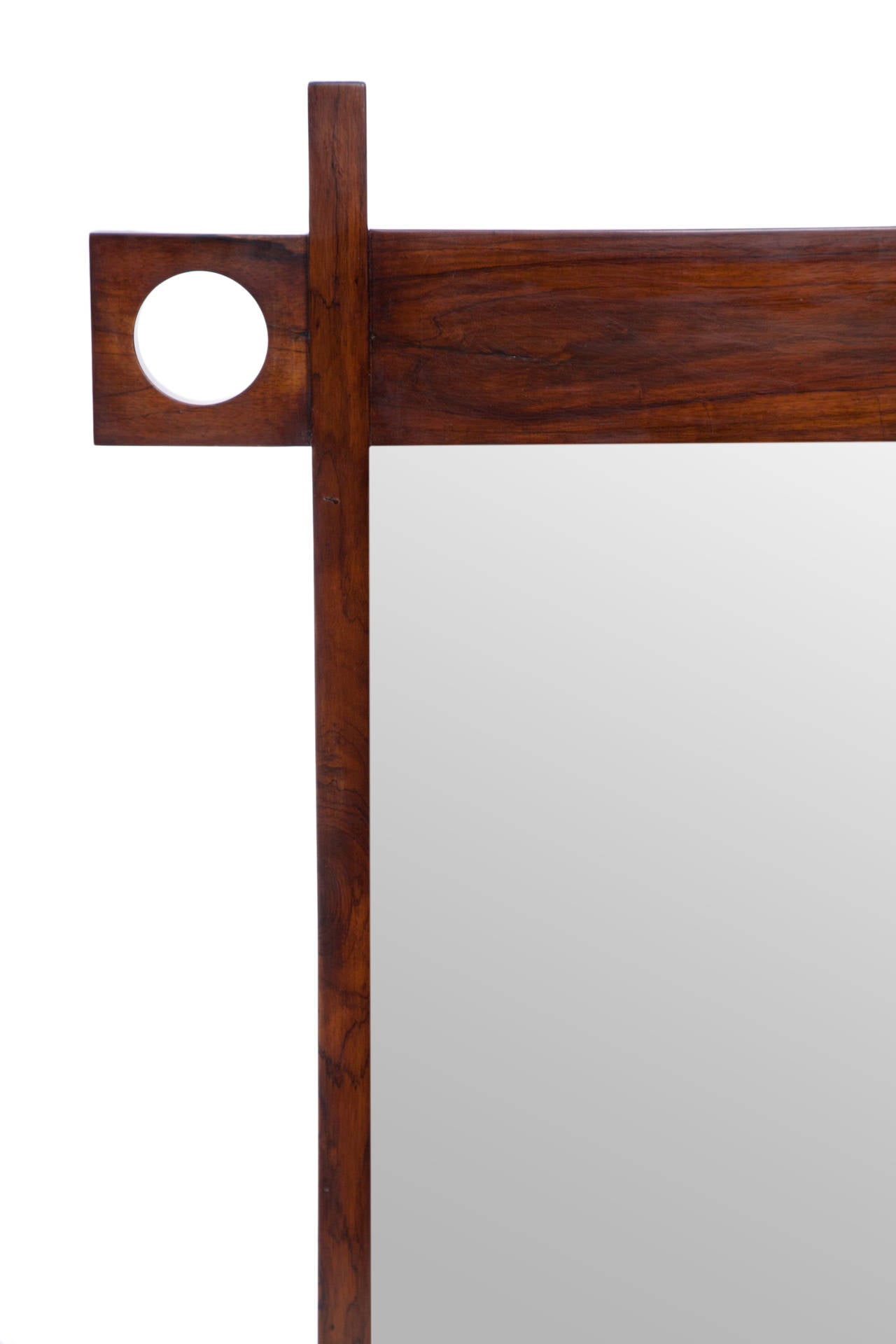 Brazilian Modern wall mirror, produced circa 1970s by architect and designer Sergio Rodrigues, from his Cuiabá series, glass set within a lacquered jacaranda wood frame. Very good vintage condition, with some presence of wear and cracking to the