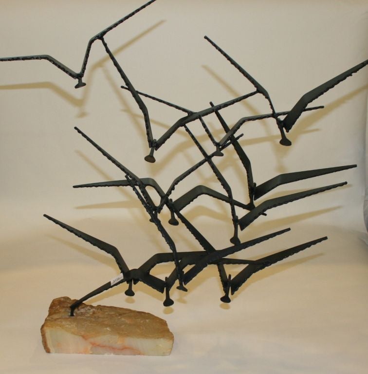 A black metal sculpture of seagulls in flight on a stone base by C. Jere. Partial signature (see image 5).