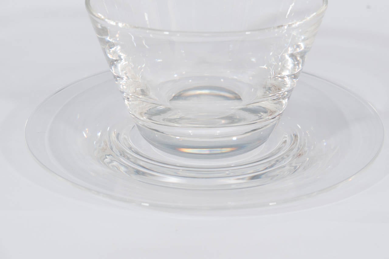 Un ensemble de 12 rince-doigts et sous-assiettes en verre dans leurs étuis d'origine par Steuben.

Mesures :
Bols : 4 1/4