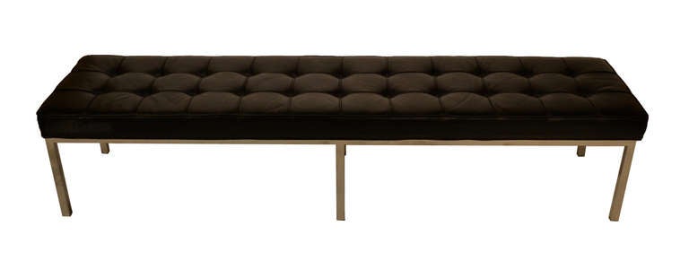 A vintage bench with chrome legs and black leather tufted cushion. The piece is by Brueton and is labeled on the underside. Vintage condition with age appropriate wear; spotting on leather.