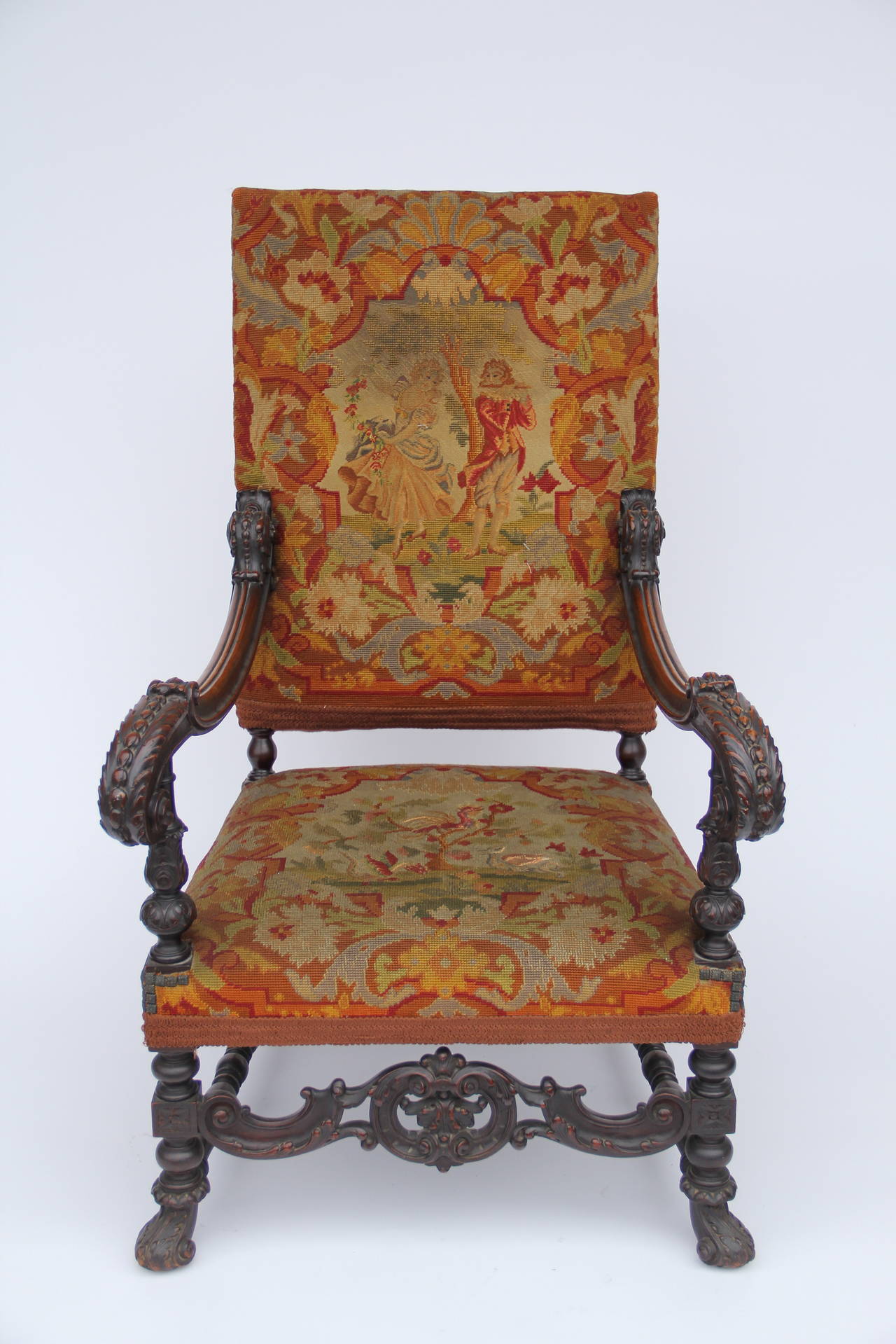 An antique very beautiful circa 1900s French Louis XIV style Fauteuil (high back armchair). The chair has been exquisitely carved from maple wood and still has its original dark walnut stain. The chair has carved claw front feet, and hand rests