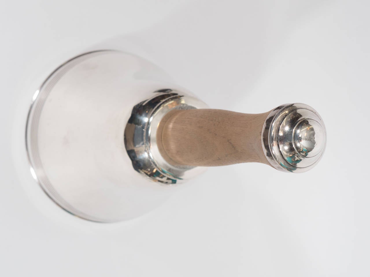 A vintage silver plate cocktail shaker with a wooden handle and in the shape of a bell, circa 1930s-1940s.

Good vintage condition with age appropriate wear. Some scratches.