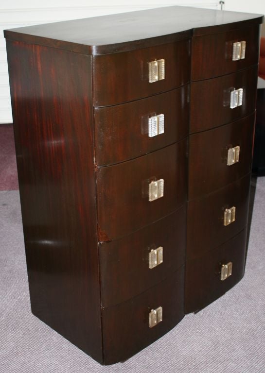 A distinctive four drawer mahogany dresser features classic Art Deco lines and lucite waffle motif drawer pulls. The top two drawers are sectioned. The bottom two are open. All drawers offer ample storage space.The dresser was originally offered by