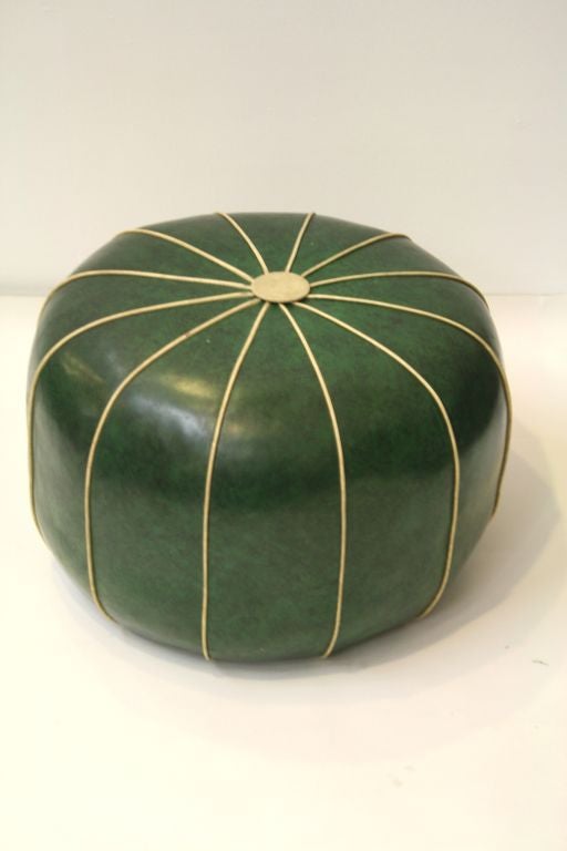 A charming retro pouf in green vinyl with a sunburst of tan vinyl piping. It can be used as an ottoman or for low casual seating in any space where a 60s Retro accent is desired.