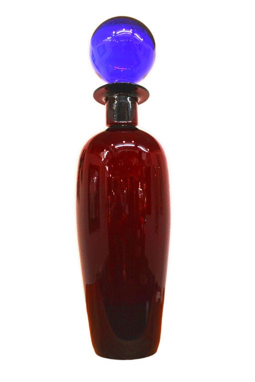 A large scale handblown Blenko decanter in Ruby with a vibrant Sky Blue stopper comes with its original Blenko sticker affixed.<br />
<br />
Reduced From: $975