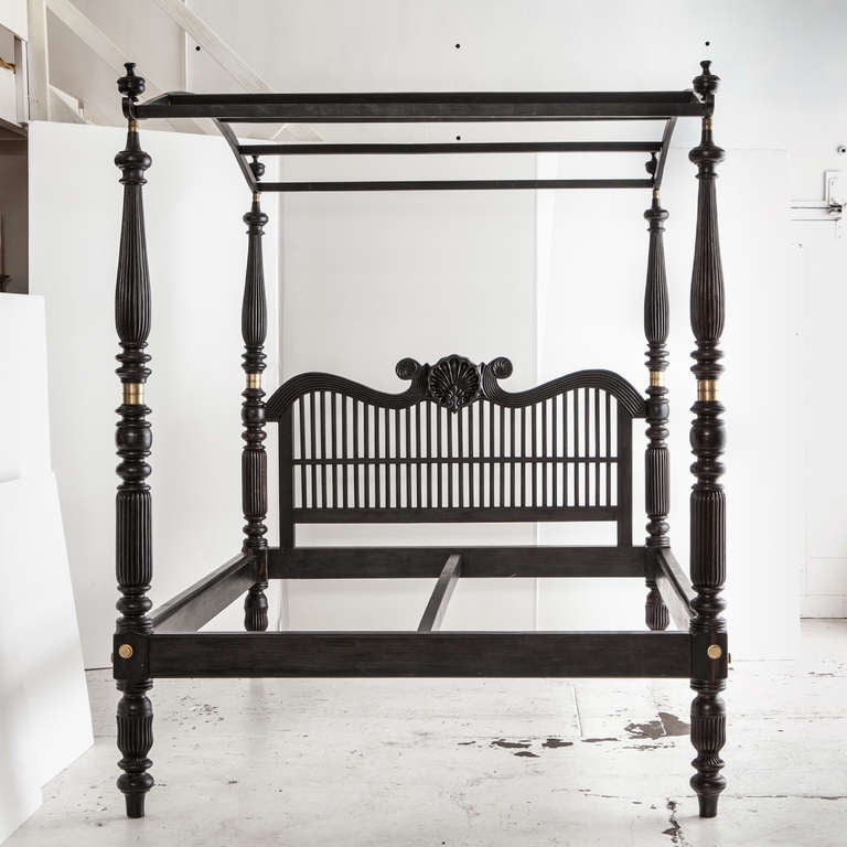 A rare and special solid ebony Indo-Dutch four poster bed with canopy. Headboard has curved top rail with carved shell design in the center above spindle turned posts.  Mattress or box spring sits directly on wooden platform. Top posts connect via