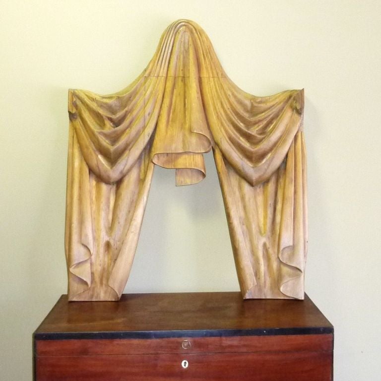 Deeply carved pinewood architectural element in the shape of a valance with side drapes. Very nice waxed wood patina.