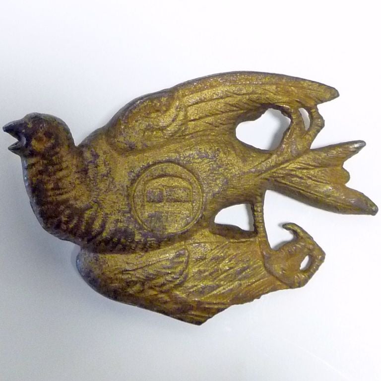 Cast iron deceased bird paperweight with remnant gilt finish. Back is stamped DB with the number 64.
